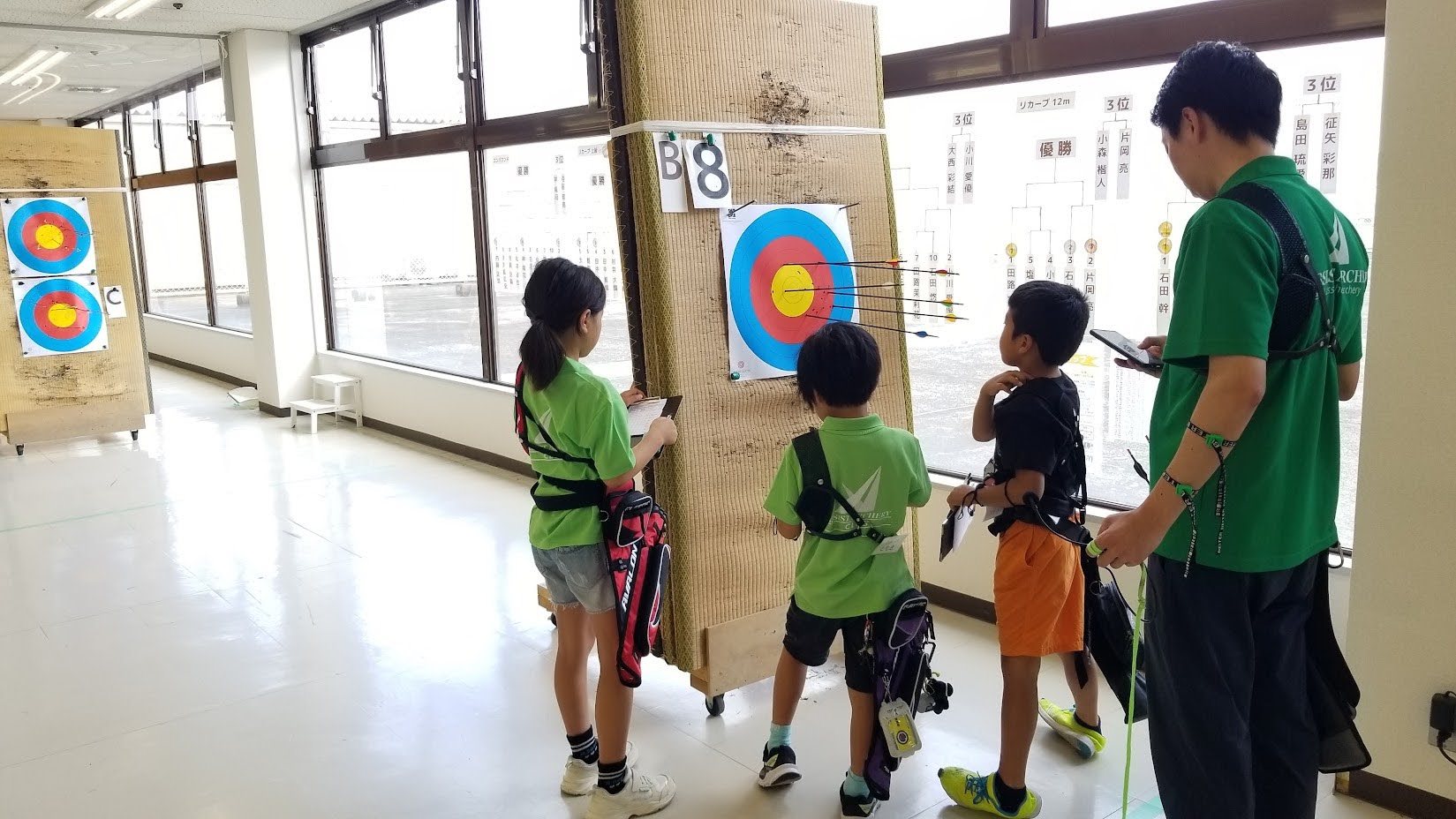 的の前で矢を抜く子どもたちとコーチ